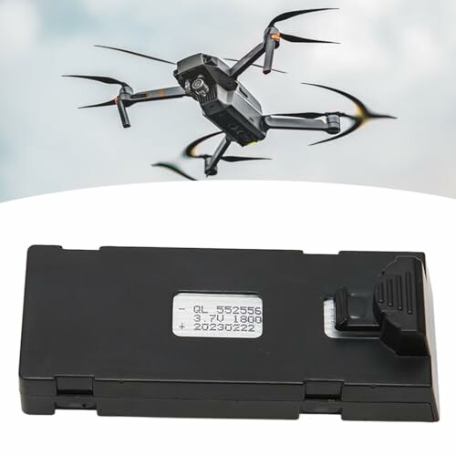 Drohne fliegt am Himmel mit Batterie im Vordergrund.