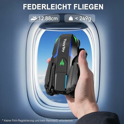 Zusammenklappbare Drohne in einer Hand vor Flugzeugfenster.